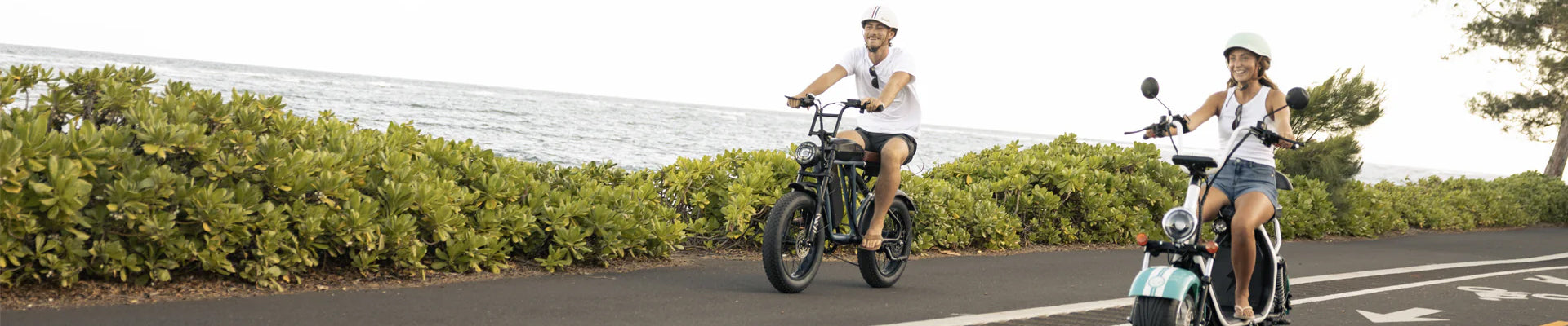 a man and woman riding island cruzers near the ocean